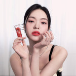 Model wearing Muziage Mansion Objet Liquid Lip Tint in Pleasure 020 demonstrating the shade in natural lighting