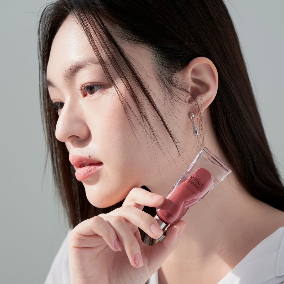 Model wearing Muzigae Mansion Objet Liquid Lip Tint in Sequence 002, demonstrating the shade in natural lighting