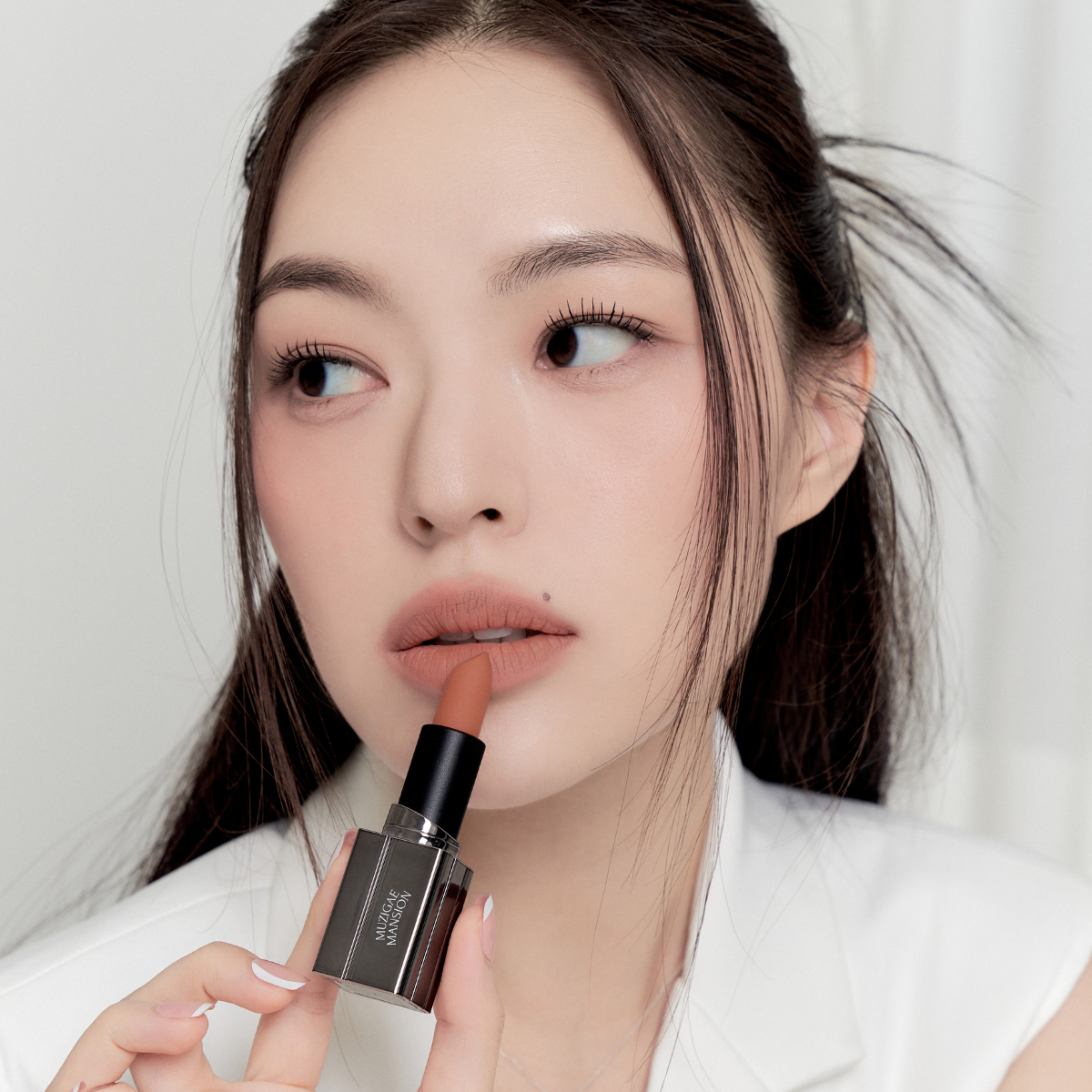 Model wearing Muzigae Mansion Moodwear Blur Semi-Matte Lipstick in 003 Nuddy, demonstrating the shade in natural lighting
