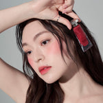 Model wearing Muzigae Mansion Objet Liquid Lip Tint in Stunning 005, demonstrating the shade in natural lighting