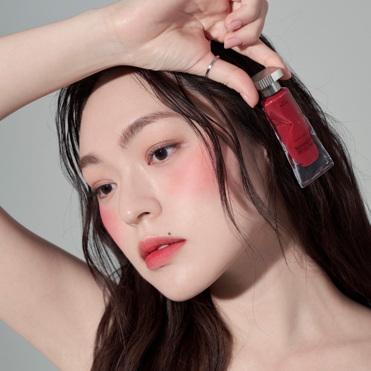 Model wearing Muzigae Mansion Objet Liquid Lip Tint in Stunning 005, demonstrating the shade in natural lighting