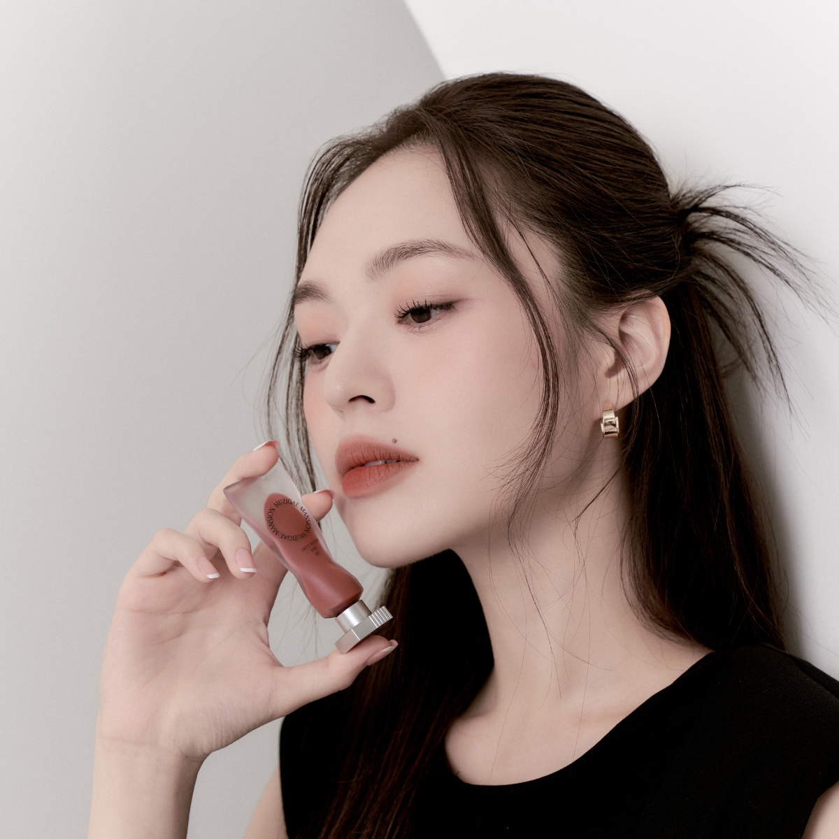 Model wearing Muzigae Mansion Objet Water Lip Tint in Rare, demonstrating the shade in natural lighting