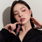 Model wearing Muziage Mansion Objet Liquid Lip Tint in Appeal 013, demonstrating the shade in natural lighting