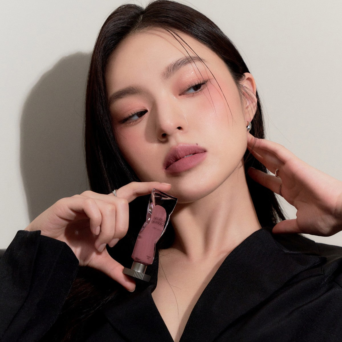 Model wearing Muziage Mansion Objet Liquid Lip Tint in Appeal 013, demonstrating the shade in natural lighting