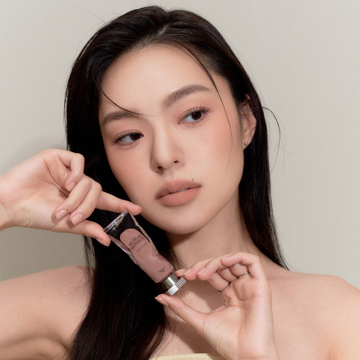 Model wearing Muziage Mansion Objet Liquid Lip Tint in Tension 014, demonstrating the shade in natural lighting