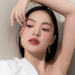 Model wearing Muziage Mansion Objet Liquid Lip Tint in After 016, demonstrating the shade in natural lighting