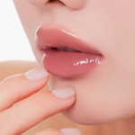 Muzigae Mansion Icy Glow Lip Gloss 10 Prim applied on lips, showing sheer, radiant shine