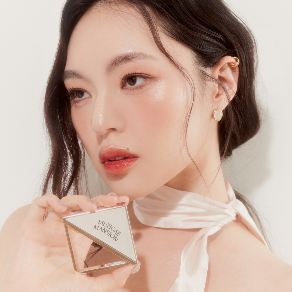 Model wearing Muzigae Mansion Fitting Blush Highlighter in Gorgeous, highlighting the luminous finish in natural lighting
